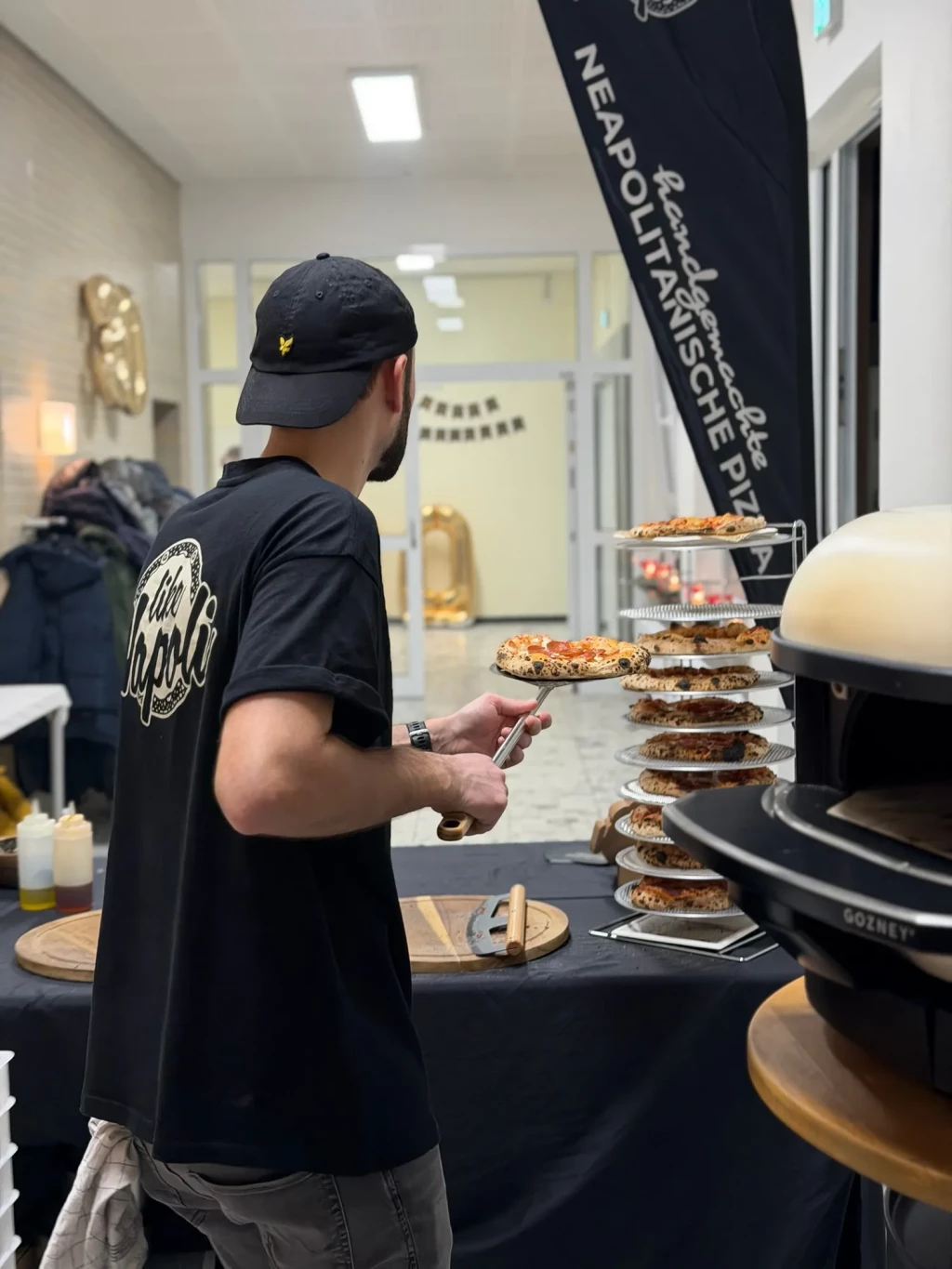 Pizzabäcker serviert eine frisch gebackene Pizza vom mobilen Ofen bei der Geburtstagsfeier in Hilligsfeld