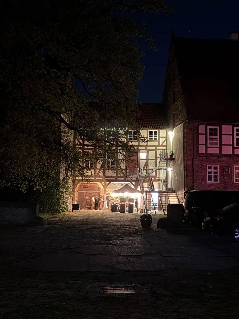 Abendstimmung bei der Hochzeit: der beleuchtete Pizzastand im historischen Innenhof des Ritterguts Goltern
